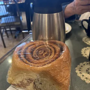 A cinnamon roll to go with a large amount of icing for it on the side.