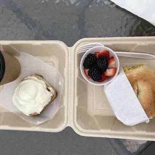 Cinnamon roll, coffee, fresh fruit, sausage egg &amp; cheese on a bagel
