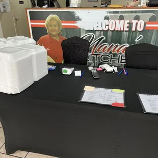 a table with a black table cloth and a sign that says come to nana's kitchen