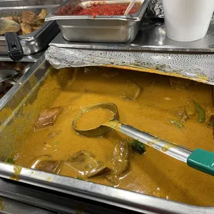 a pan of curry with a spoon in it