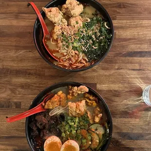 two bowls of food on a wooden table