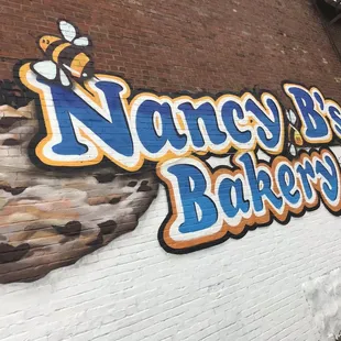 a brick wall with a sign that says nancy b's bakery