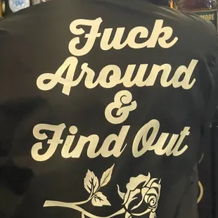 the back of a woman's jacket with a rose on it