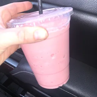 a pink drink in a plastic cup