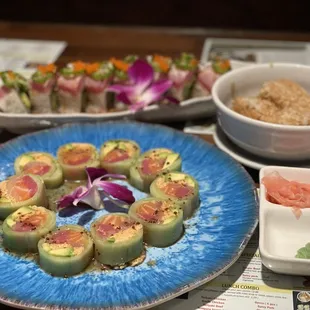 a plate of sushi rolls and bowls of sushi