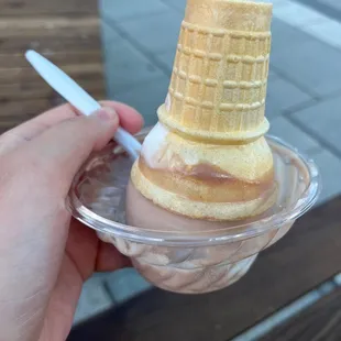a hand holding a cone of ice cream