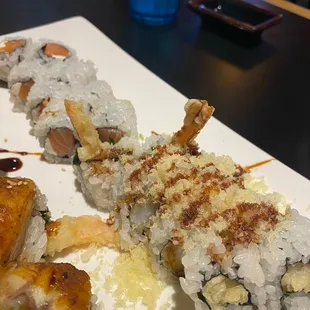 The Crunchy Shrimp Tempura Roll has the crumbles on top. The Philadelphia Roll is in back.