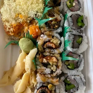 a variety of sushi in a styrofoam container