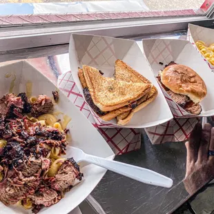 a plate of pulled pork, macaroni, and cheese sandwich