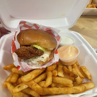 Chicken sandwich combo with fries and two sauces.