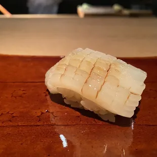 a piece of sushi on a brown plate