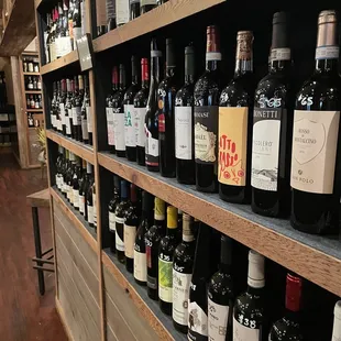 Back wall is decorated with a bunch of bottles of wine