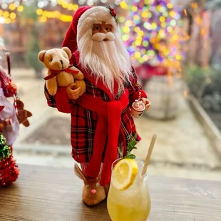 santa holding a teddy bear and a glass of lemonade
