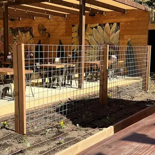 a fenced area with tables and chairs