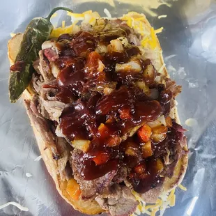 16 oz Tri - Tip sandwich with grilled onions , grilled bell peppers with Colby Jack cheese on a toasted hoagie and Serrano pepper