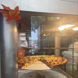 a pizza in a glass display case