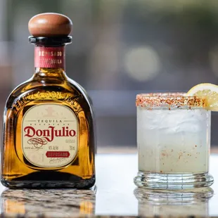 a bottle of donutuo next to a glass of margarita