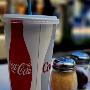 a coca cola cup with a straw