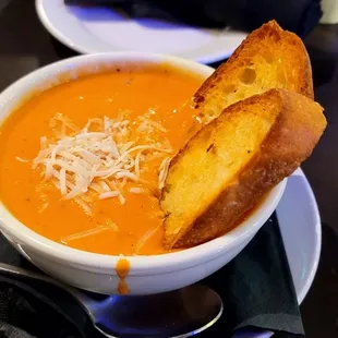 a bowl of tomato soup with grilled cheese