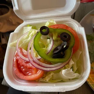 a salad in a styrofoam container