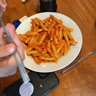 a plate of pasta and a pepsi bottle