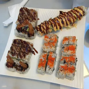 a plate of sushi and rolls