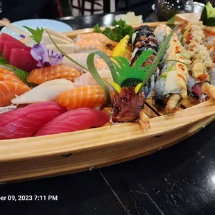 a wooden boat filled with sushi