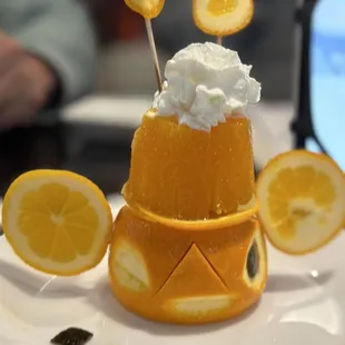 an orange with whipped cream on top