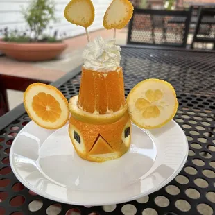 a plate with an orange and whipped cream