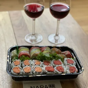two glasses of wine and a tray of sushi