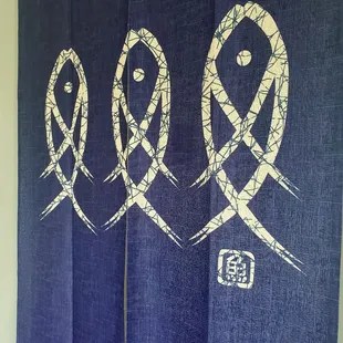 a blue curtain with three fish drawn on it