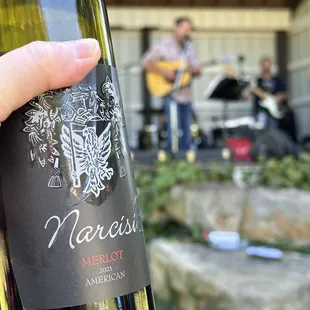 a hand holding a bottle of wine