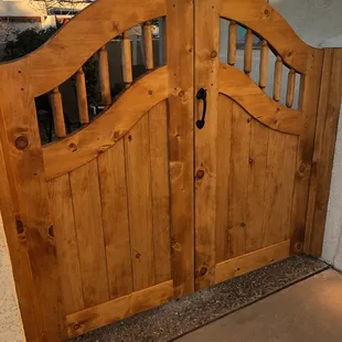 Pine double entry gate with arch top and arched latilla window.
