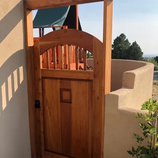 Spanish Cedar gate with a speak easy door and latilla window, arch top.