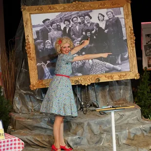 a woman pointing at a large picture