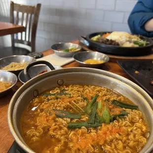 a bowl of ramen with a side of vegetables