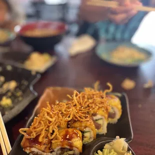 a plate of sushi with chopsticks