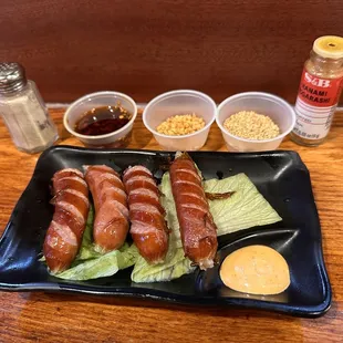 a plate of hot dogs with lettuce and mustard