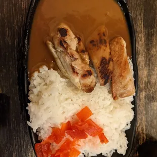 a plate of rice, meat, and vegetables