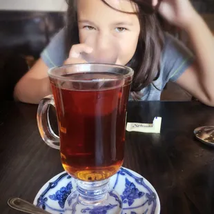 a little girl drinking tea