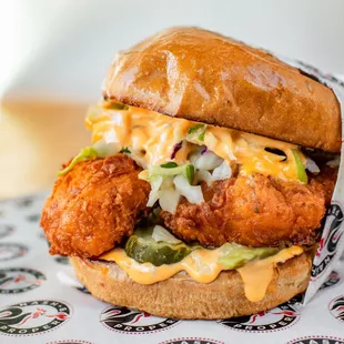 a chicken sandwich with cheese and pickles