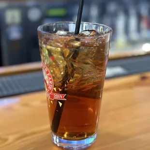 a glass of iced tea on a bar