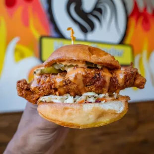a hand holding a chicken sandwich