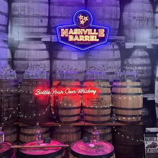 barrels of whiskey and a neon sign