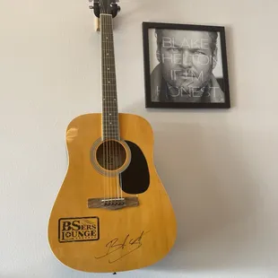 an acoustic guitar with a signed photo