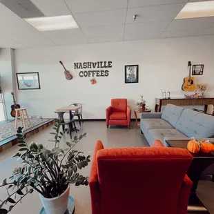 a living room with couches and a guitar