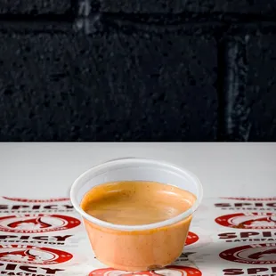 a cup of sauce on a table