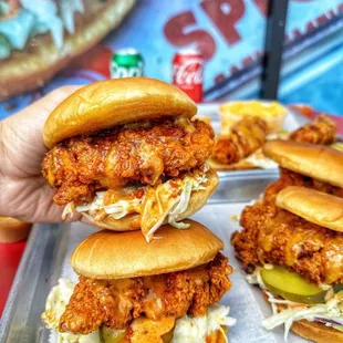 a hand holding a chicken sandwich