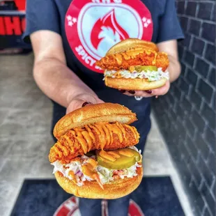 a man holding two sandwiches