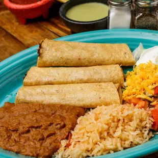 Flautas 3 Fried corn tortillas filled with chicken or beef, with sour cream, guacamole and shredded cheese, served with rice &amp; refried beans